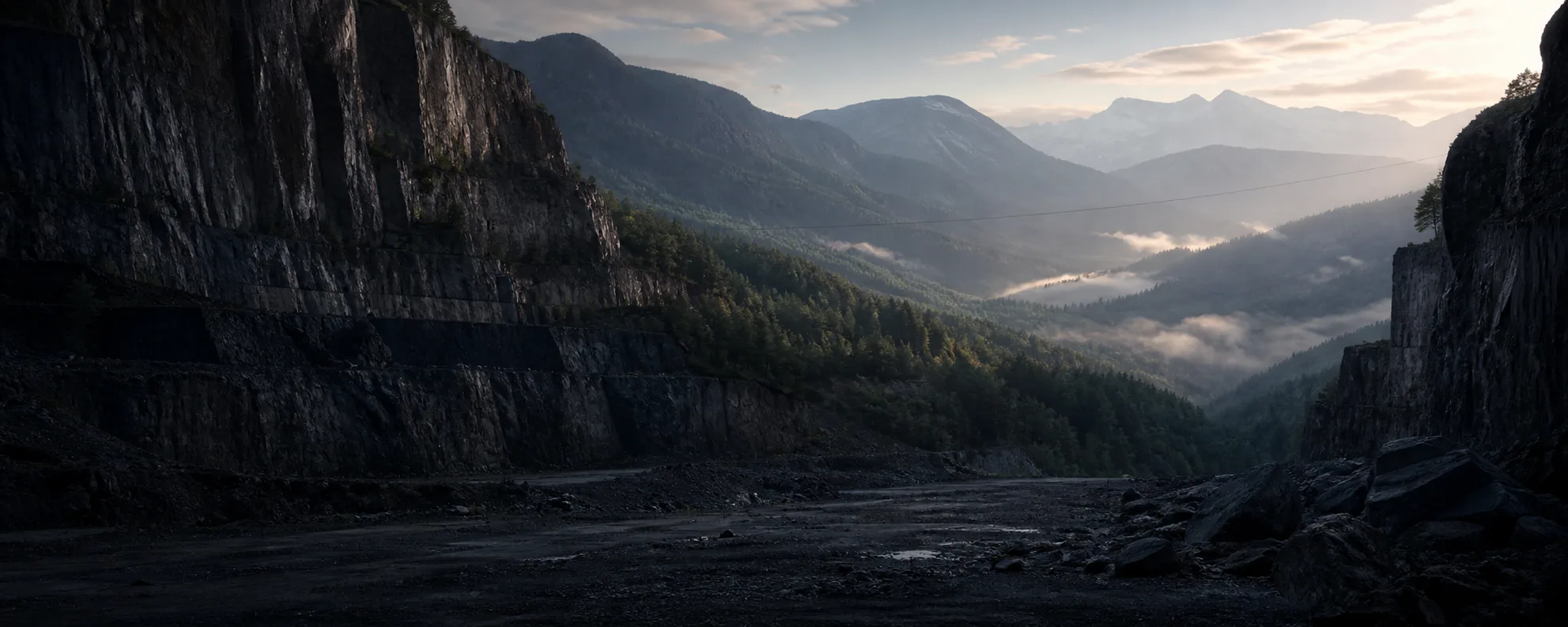 A dramatic mountain quarry opening toward a misty alpine valley